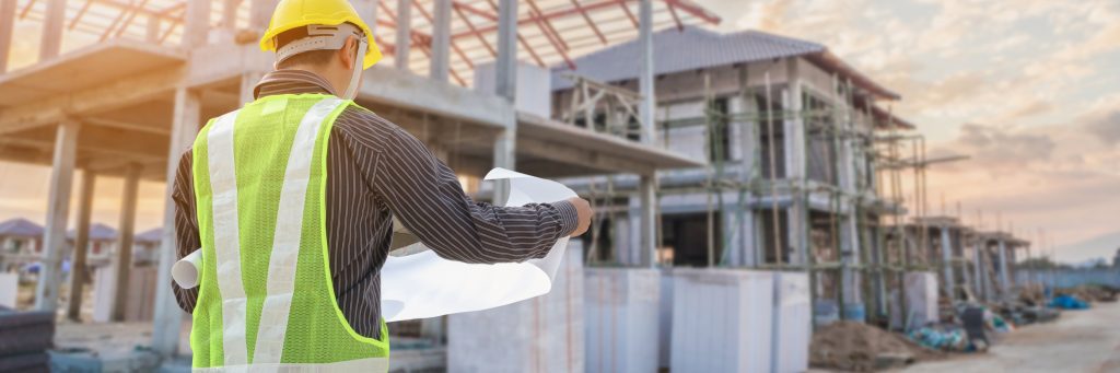 Construction worker or developer reviewing plans at a site needing wastewater connections.