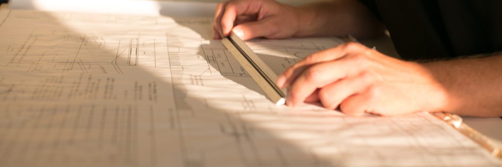 Schematics on a drafting table showing sanitary sewer extensions for developers.