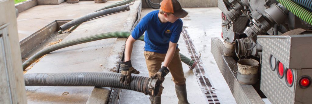 A septage hauler connecting a disposal hose to the truck as a way to do business with us.