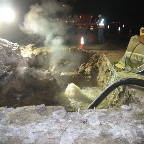 Excavation of the forcemain pipe on Monona Drive with a hose to pump out wastewater collecting in the hole.