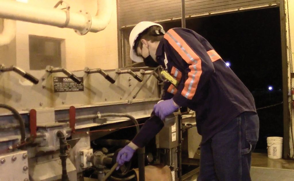 A night shift operator collects a GBT filtrate sample while conducting rounds at the wastewater treatment plant.
