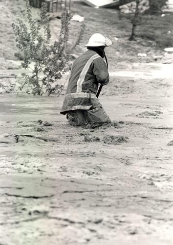 A firefighter wades thigh-deep in the Butter River. Credit: The Capital Times