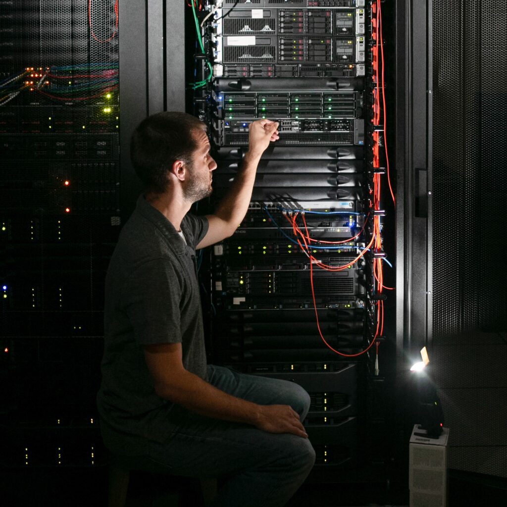 An information technology (IT) professional checks the computer network in a dark room.