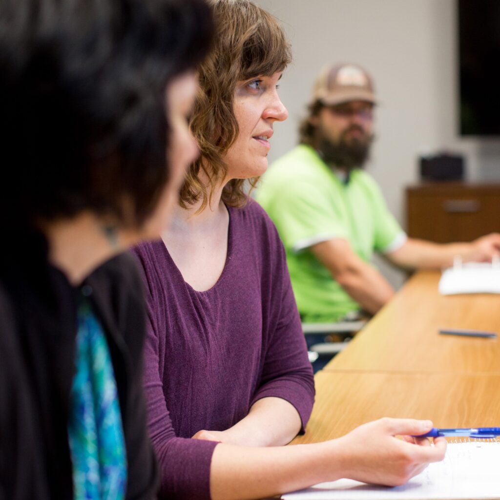 District staff sitting at a table in a meeting or interview, with paperwork in front of them.