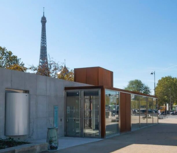 The exterior of the Paris Sewers Museum with the Eiffel Tower in the skyline.