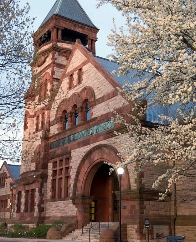 The Metropolitan Waterworks Museum exterior, located in Boston, Massachusetts, with a blooming tree in the foreground.