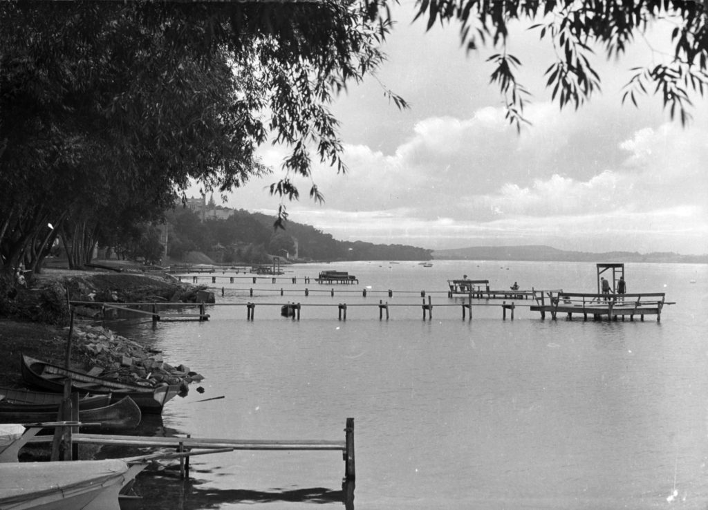 A historic photo of wooden piers and canoes along the Lake Mendota shoreline. Image copyright, used with permission: Wisconsin Historical Society, WHI-79059.