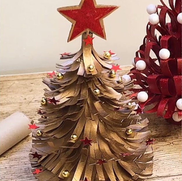 Tabletop toilet paper roll Christmas tree craft, with feathered needles and spray painted gold with balls and red stars.