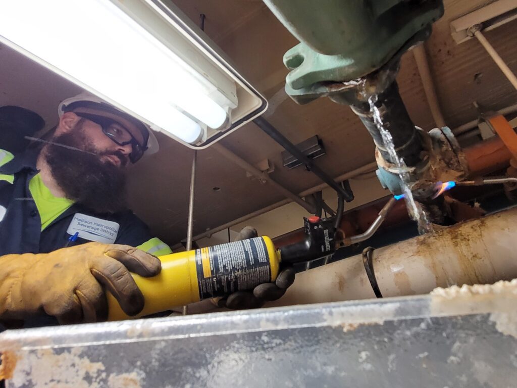 Stuck bolts can be encouraged to open with a little heat. Cory Pieper uses a torch to help loosen the stubborn bolt.