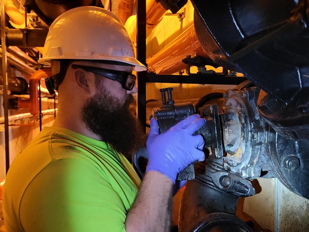 Cory Pieper removes a valve actuator, the mechanical part of a valve that turns the inner plug.