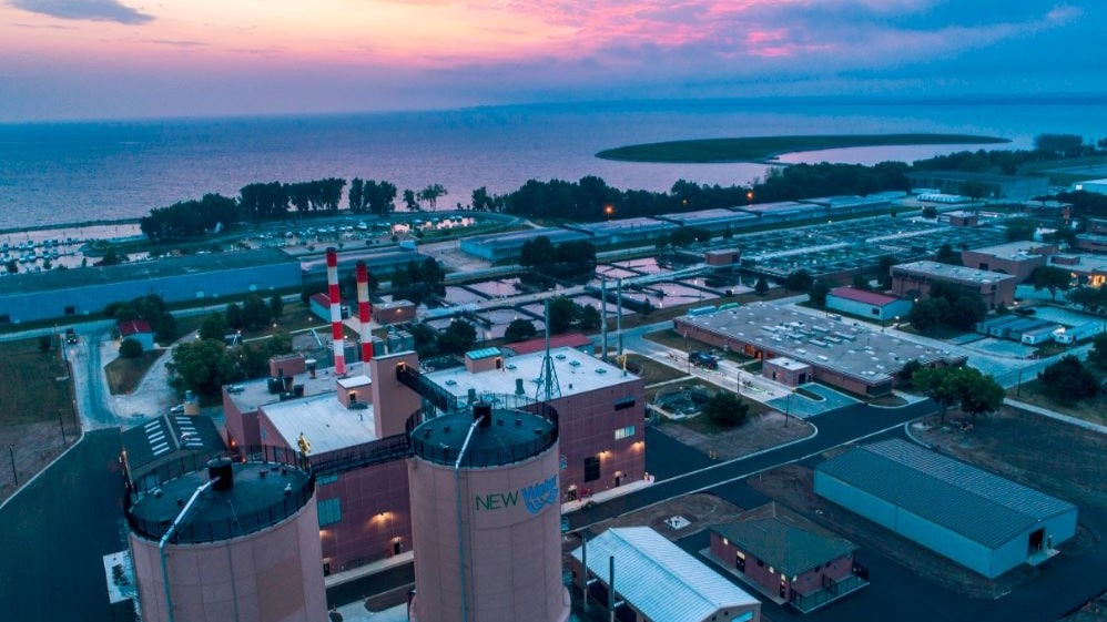 NEW Water, the brand of the Green Bay Metropolitan Sewerage District, as seen in a sunset aerial view overlooking the shoreline of Green Bay on Lake Michigan.