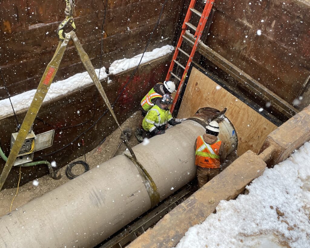 A 42-inch diameter Hobas jacking pipe is placed in the frame skid. The pipe is partially inserted into the tail of the microtunnel power cutting head and in a push ring at the head of the jacking frame.