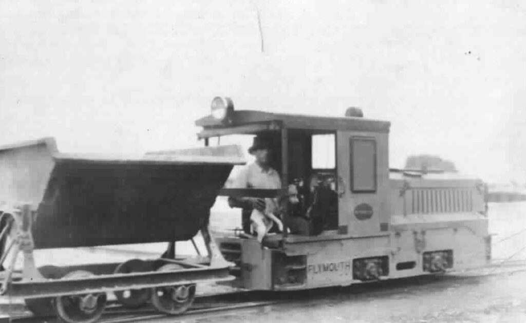 A District worker operates a sludge locomotive in the 1930s, used to transport dried sludge from the sludge drying beds at the treatment plants after workers shoveled it into the cars.