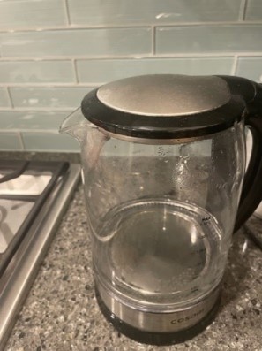 A flat-bottomed glass kettle being cleaned with vinegar.