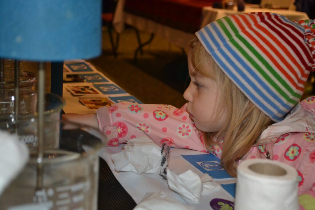 A young explorer examines a water science exhibit.