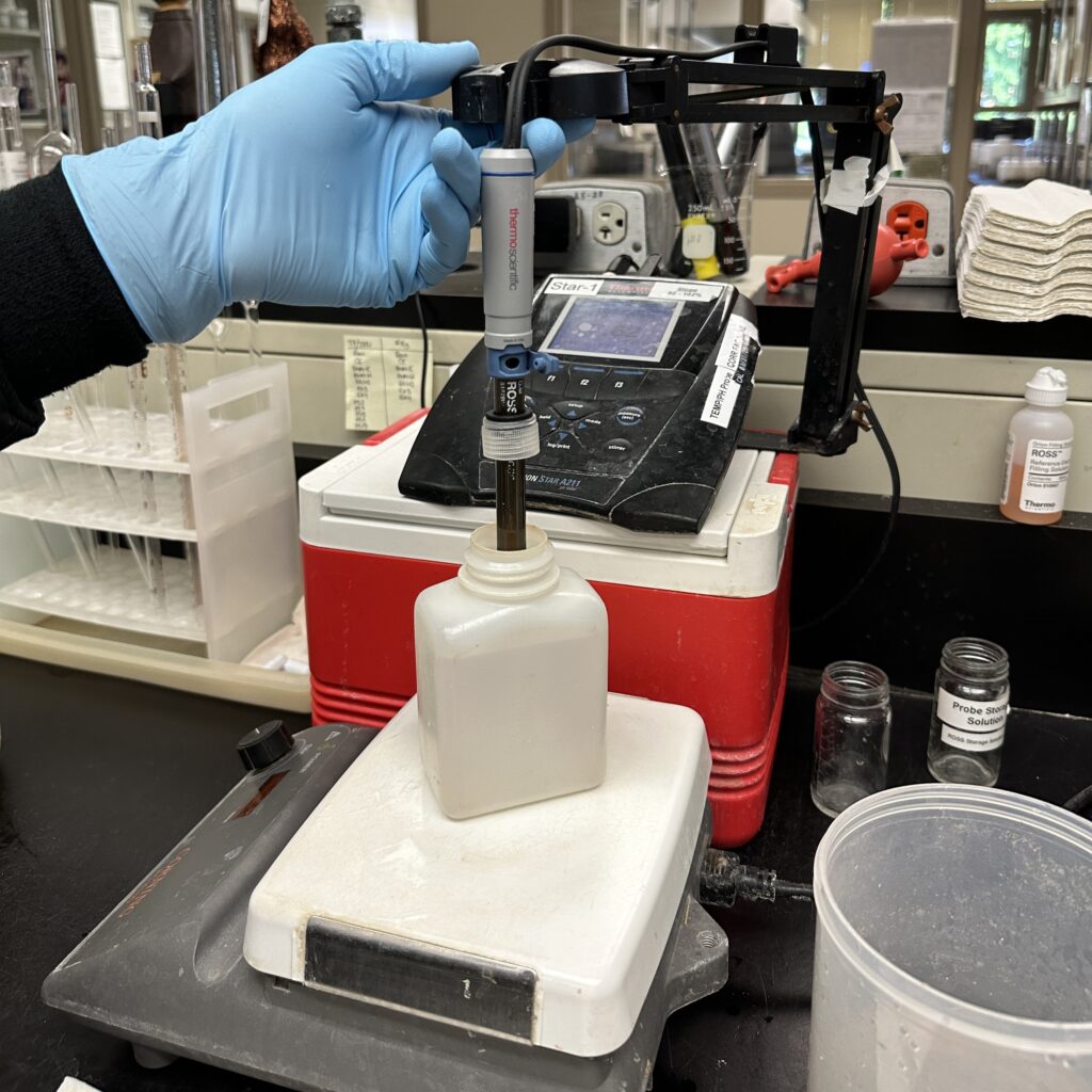 A chemist tests pH using a pH meter.