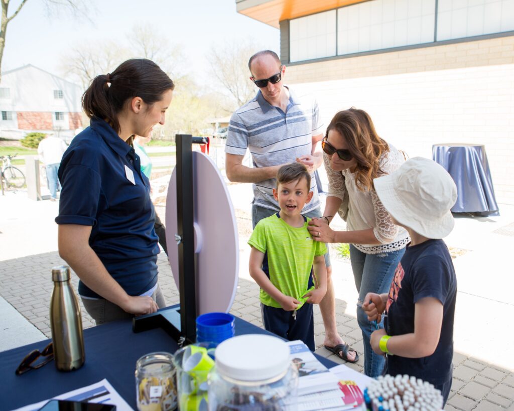 A family plays a fun activity at an open house event.