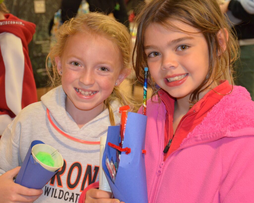 Two young explorers smile at a water science event.