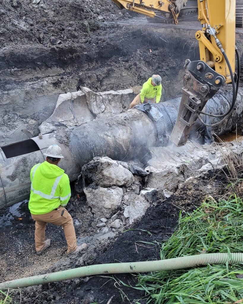 Capitol Underground workers remove the temporary band and concrete collar installed in August. A window was cut on the top of the pipe to pump any remaining water to PS 3.