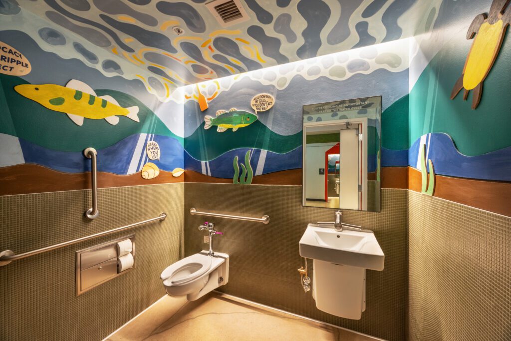 The advocacy-themed bathroom at the Madison Public Market features a beautiful underwater mural with messages of how you can use your voice.