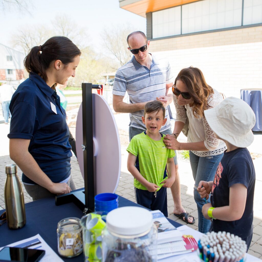 A pollution prevention specialist helps a family learn about pollutants at an outreach event.