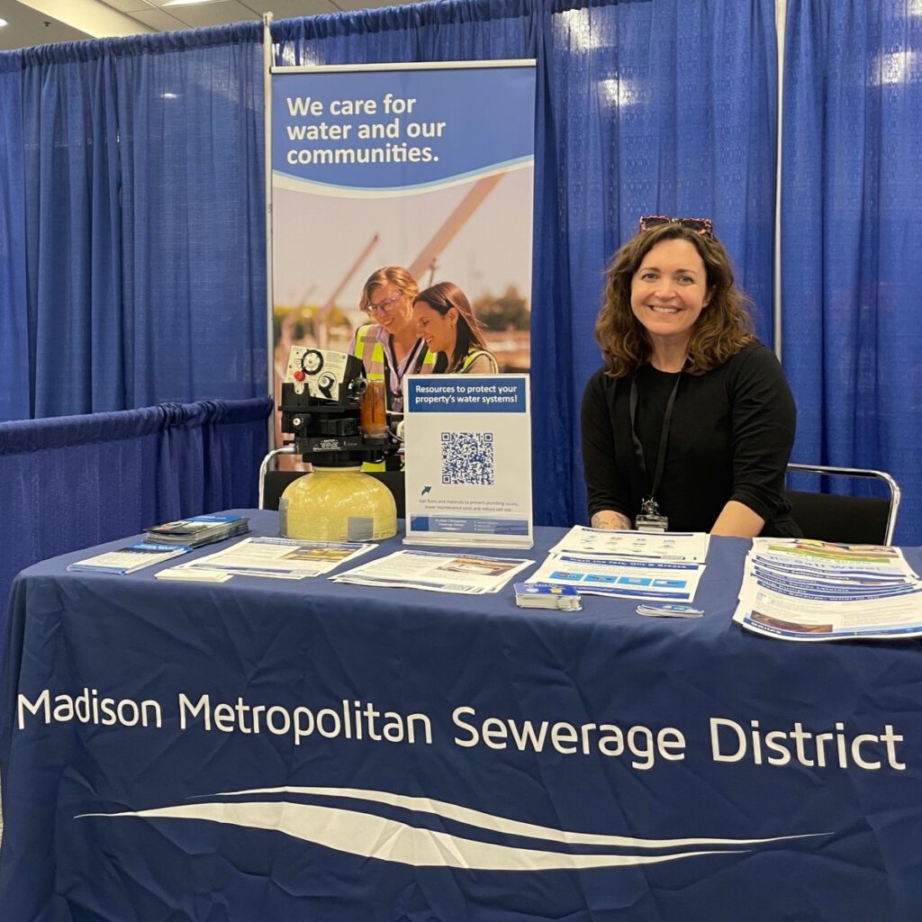 A pollution prevention specialist sets up a District table at a community outreach event.